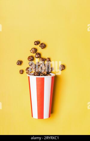 Süßes Schokoladenpopcorn in weiß-roter Tasse mit Papierstreifen Stockfoto