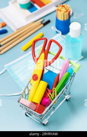 Schulzubehör, poppit Anti-Stress, Gesichtsmaske, Flasche Desinfektionsmittel, für Schulbeginn auf blauem Hintergrund. COVID-19-Vorsichtsmaßnahme Stockfoto