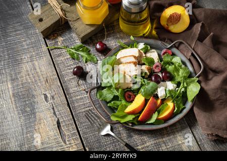 Gesunder Diät-Salat mit gegrilltem truthahn, Rucola, Pfirsich, Kirsche, Feta und Vinaigrette Dressing auf einem rustikalen Tisch. Keto Diät Mittagessen Stockfoto