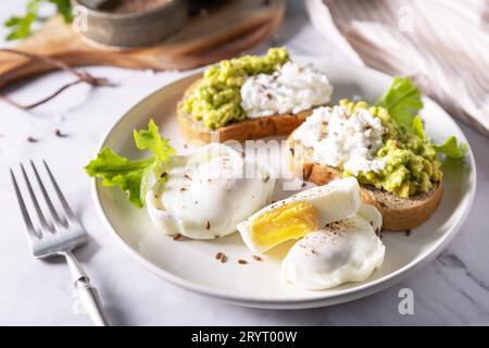 Osterfrühstück oder Brunch. Pochierter Ei- und Rübensalat mit Spinat, Käsefeta, Kichererbsen auf einer Marmorplatte. Stockfoto