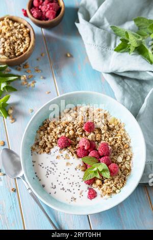 Gesunde Frühstückszerealien Schale hausgemachtes Müsli mit frischen Himbeeren und Chiasamen auf einem rustikalen Tisch. Ernährungskonzept. Stockfoto