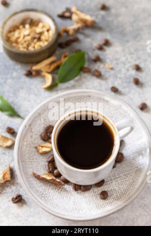 Gesundes organisches, energiegeladenes Adaptogen, trendiges Getränk. Pilzkaffee in einer Tasse mit Kaffeebohnen. Stockfoto