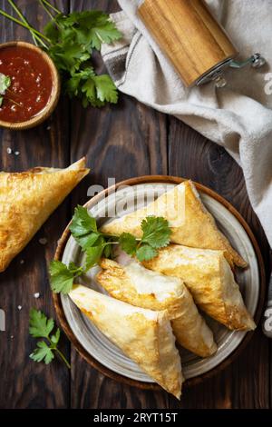 Asiatisches Essen. Vegetarische samsa (Samosas) mit Tomatensauce auf einem Holztisch. Beliebt in Indonesien als Risoles Sayur. Ansicht von abo Stockfoto
