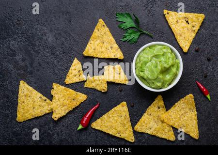 Traditioneller mexikanischer Snack mit Guacamole und Maischips auf schwarzem Hintergrund Stockfoto
