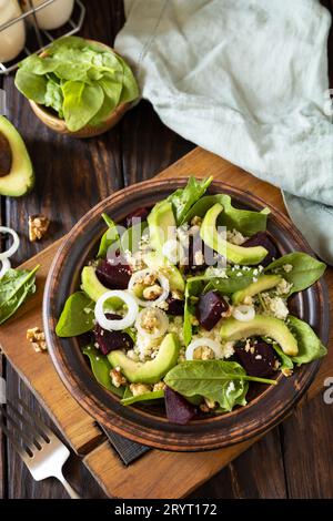 Couscous mit Avocado, Rüben, grünen Bohnen, Spinat auf einem rustikalen Holztisch. Veganes Essen. Stockfoto