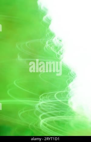 Defokussieren Sie die grüne Bewegung, und verwischen Sie den wirbelnden Hintergrund. Farbenfrohe grüne Wirbel verwischen den Hintergrund. Stockfoto
