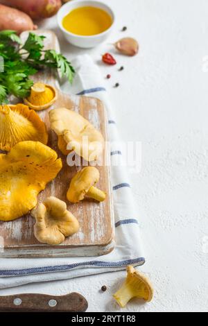 Rohe Pfifferlinge auf einem Schneidebrett Nahaufnahme auf weißem Hintergrund Stockfoto