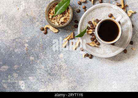 Gesundes organisches, energiegeladenes Adaptogen, trendiges Getränk. Pilzkaffee in einer Tasse mit Kaffeebohnen. Blick von oben. Speicherplatz kopieren. Stockfoto
