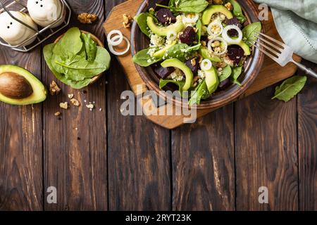 Couscous mit Avocado, Rüben, grünen Bohnen und Spinat auf einem rustikalen Holztisch. Veganes Essen. Blick von oben. Speicherplatz kopieren. Stockfoto