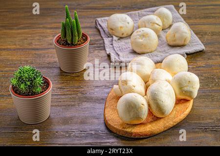 Eine Auswahl an frischen Pilzen auf einem rustikalen Holztisch mit einer Auswahl an üppigen grünen Pflanzen. Stockfoto