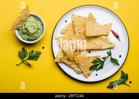 Traditionelles mexikanisches Essen Guacamole mit Maischips auf gelbem Hintergrund Stockfoto