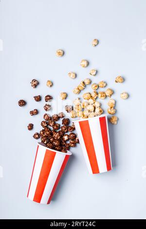 Süßes Karamell-Schokoladen-Popcorn in papiergestreifter weißer roter Tasse Stockfoto