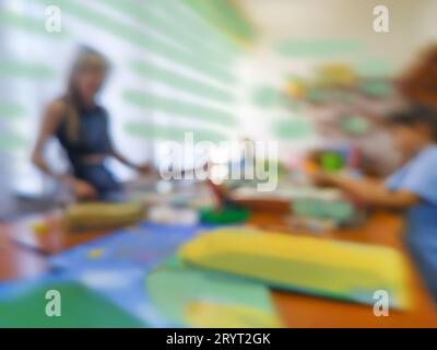 Lehren Sie Kunstunterricht in Person mit unfokussiertem fotografischem Effekt. Gruppe von Leuten, die im Kunststudio zeichnen, verschwimmen Hintergrund. Stockfoto