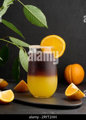 Eiskaffee mit Orangensaft in einem durchsichtigen Glas, erfrischender Hummelkaffee auf dem Tisch Stockfoto