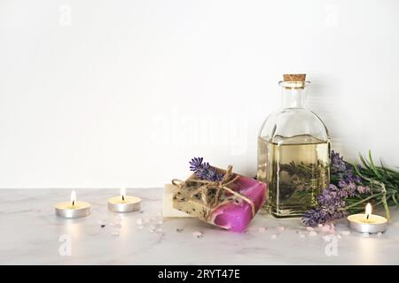 Spa-Einrichtung, Lavendelkosmetika und brennende Kerzen. Home Body Hautpflege, Spa Aromatherapie Hintergrund Stockfoto