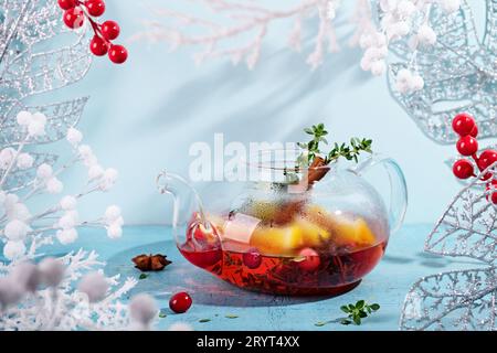 Immunitätssteigerungsgetränk. Wintertee mit Preiselbeeren, Orangen und Gewürzen in einer Teekanne aus Glas Stockfoto