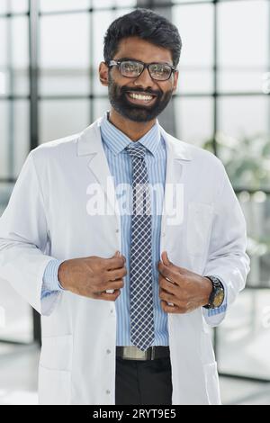 Porträt eines lächelnden männlichen Arztes, der in einem Krankenhausgang steht Stockfoto