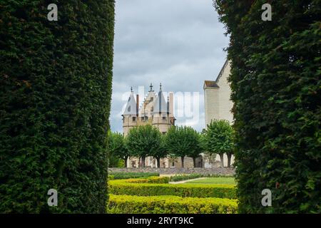 Angers, Frankreich, 2023. Das Châtelet (Torhaus) kontrolliert den Zugang zu den inneren Stationen, durch den Bogen einer Eibenlaube im formellen Garten gesehen Stockfoto