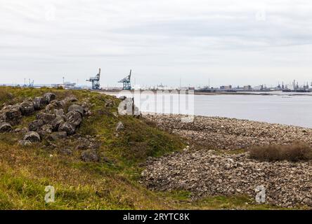 Ein Blick auf Teesport von South Gare, Redcar, England, Großbritannien mit seinem felsigen Strand und Industriekränen im Hintergrund Stockfoto