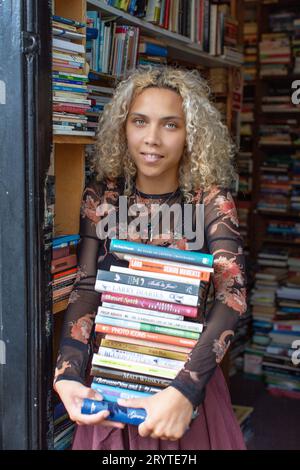 GREAT BRITAN / London / Hurlingham Books / Attraktive Frau mit einem Stapel Bücher. Stockfoto