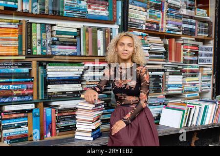 GREAT BRITAN / London / Hurlingham Books / Attraktive Frau mit einem Stapel Bücher. Stockfoto