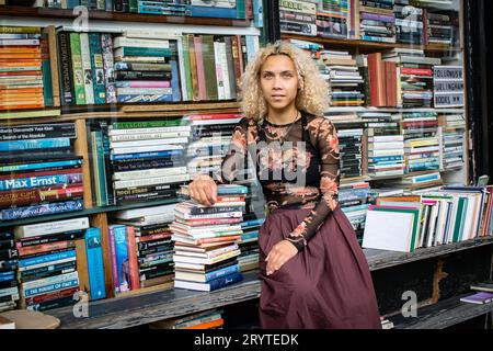 GREAT BRITAN / London / Hurlingham Books / Attraktive Frau mit einem Stapel Bücher. Stockfoto