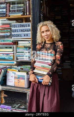 GREAT BRITAN / London / Hurlingham Books / Attraktive Frau mit einem Stapel Bücher. Stockfoto