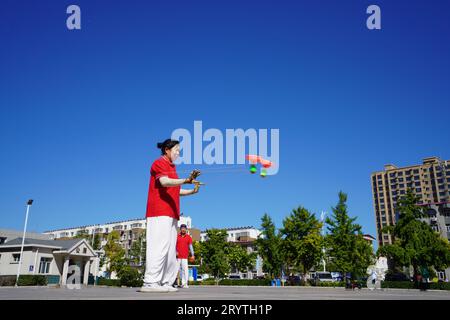 Luannan County, China - 22. August 2023: diabolo-Aufführung wird auf einem Platz aufgeführt. Stockfoto