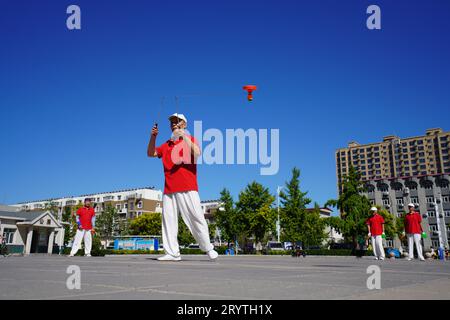 Luannan County, China - 22. August 2023: diabolo-Aufführung wird auf einem Platz aufgeführt. Stockfoto