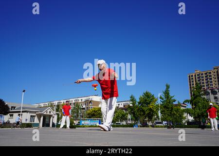 Luannan County, China - 22. August 2023: diabolo-Aufführung wird auf einem Platz aufgeführt. Stockfoto