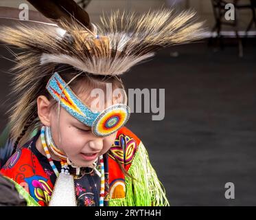 Calgary, Alberta, Kanada. Juni 2023. Eine mittelgroße Aufnahme eines Talents eines indigenen Kindes, das ein gelbes traditionelles Tuch trägt Stockfoto