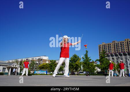 Luannan County, China - 22. August 2023: diabolo-Aufführung wird auf einem Platz aufgeführt. Stockfoto