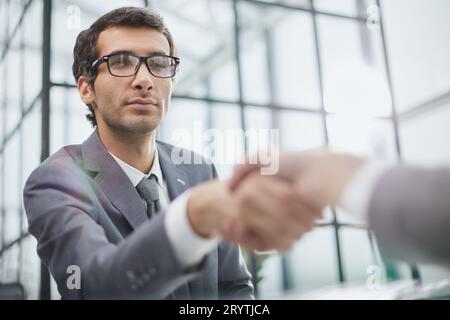 Junger Geschäftsmann, der seinem Partner die Hand schüttelt Stockfoto