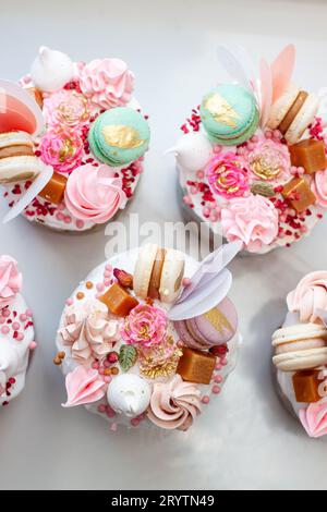 Festliche Collage mit orthodoxem osterbrot, reich dekoriert mit Süßigkeiten, Makronen, Schokolade und essbaren Blumen Stockfoto