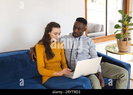 Verschiedene Paare sitzen auf dem Sofa mit Laptop zu Hause Stockfoto