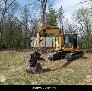 Gelber Bagger oder Bagger, wird zur Vorbereitung einer Baustelle für ein neues Haus auf einer Baustelle verwendet. Stockfoto