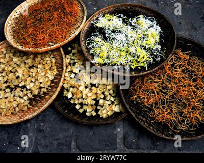 Mehrere Keramikschüsseln mit einer Auswahl an frischen und nahrhaften Speisen auf einem rustikalen Steintisch Stockfoto