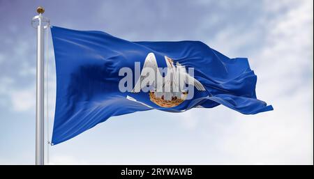 Die Flagge des Bundesstaates Louisiana weht an klaren Tagen. Mutter Pelikan in einem blauen Bereich mit dem Slogan des Staates. US-Bundesstaat. 3D-Illustrations-Rendering. Flattern f Stockfoto