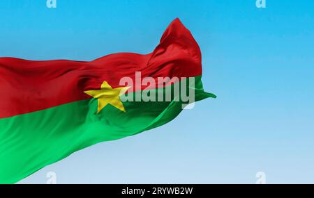 Die Nationalflagge von Burkina Faso winkt im Wind an klaren Tagen. Zwei gleiche horizontale rote und grüne Streifen mit einem gelben fünfzackigen Stern im Zentrum Stockfoto