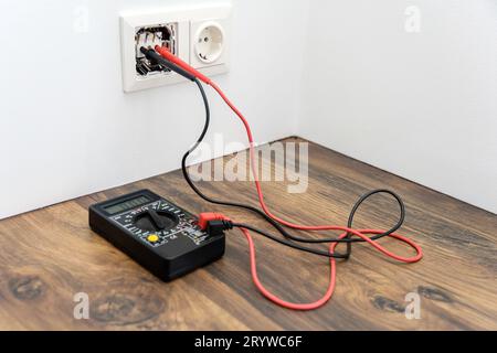 Ein Paar Drahtsonden wird in die Buchse gesteckt. Multimeter zur Spannungsmessung. Stockfoto