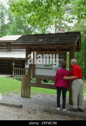 Das Foto zeigt ein Seniorenpaar, das das Informationsschild im Kings Mountain State Park Welcome Center South Carolina USA sieht. Stockfoto