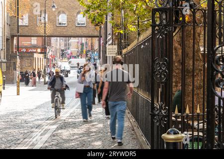 Leute, die die Brick Lane entlang laufen, vorbei an der Truman Brewery, London, E1. Stockfoto