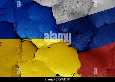 Fahnen der Ukraine und Russlands auf gerissener Wand gemalt Stockfoto