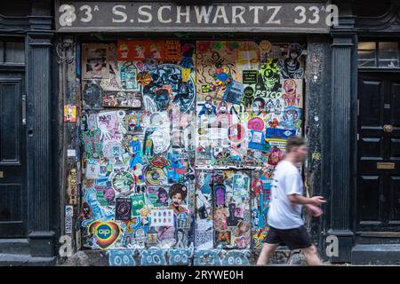 Ein Mann geht am Eingang von S Schwartz in Fournier St E1 vorbei. Stockfoto