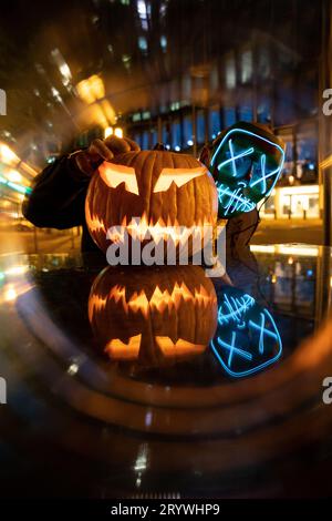 Nacht der Säuberung: Person mit LED-Maske und Halloween-Kürbis in Frankfurt Stockfoto