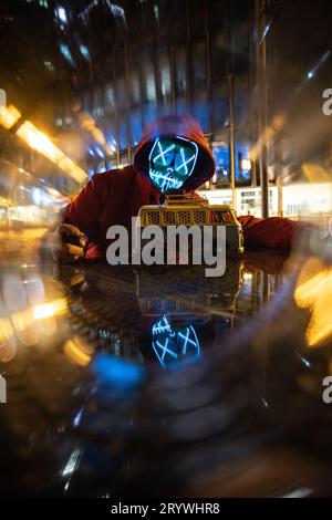 Nacht der Säuberung: Person mit LED-Maske und Halloween-Kürbis in Frankfurt Stockfoto