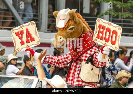 Calgary, Alberta, Kanada. Juli 2023. Harry, das Horse Stampede Maskottchen mit ein paar Schildern, auf denen YAHOO bei einem öffentlichen Vater stand Stockfoto