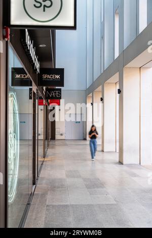 Eine Frau spaziert durch die neu entwickelte London Fruit and Wool Exchange in Brushfield St, London E1. Stockfoto