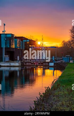 Dramatischer und farbenfroher Sonnenuntergang Himmel über einer Zugbrücke auf einem Kanal Stockfoto