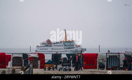 02.10.2023 Bensersiel, Esens, Ostfriesland, Niedersachsen, Deutschland - Insel Fähre vor dem Strand mit Strandkörbe und Menschen mit Bollerwagen - Symbolbild Nordsee, Urlaub, Wattenmeer, Herbst, Friesland *** 02 10 2023 Bensersiel, Esens, Ostfriesland, Niedersachsen, Deutschland Inselfähre vor dem Strand mit Liegestühlen und Menschen mit Trolleysymbol Bild Nordsee, Urlaub, Wattenmeer, Herbst, Frisia Credit: Imago/Alamy Live News Stockfoto